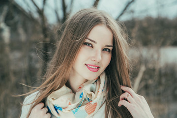 Portrait of a beautiful girl. Cold spring, windy weather.
