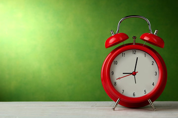 red wind-up alarm clock on wooden background