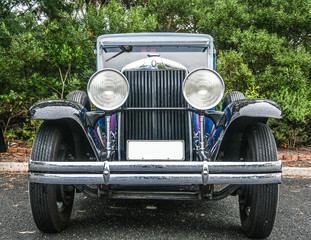 Front grill and round headlights of restored vintage gangster car.