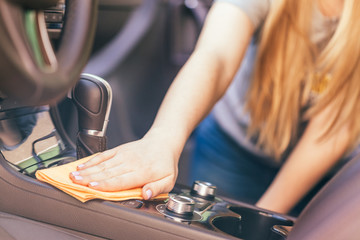 Hand with microfiber cloth cleaning car