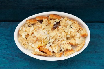 Baked panettone pudding in oval baking dish on navy blue