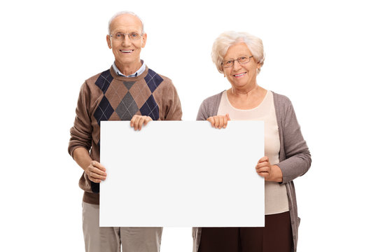 Senior couple posing with a signboard