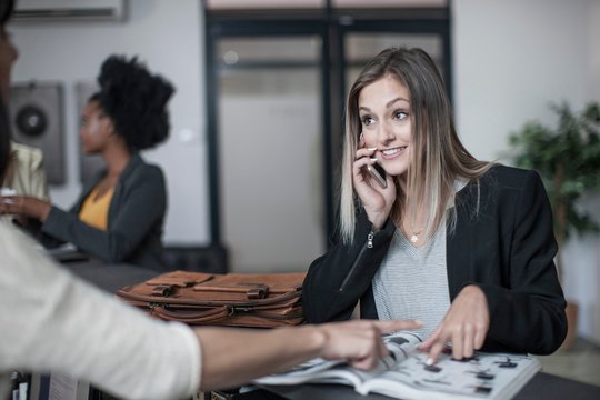 Young businesswoman making query at office reception