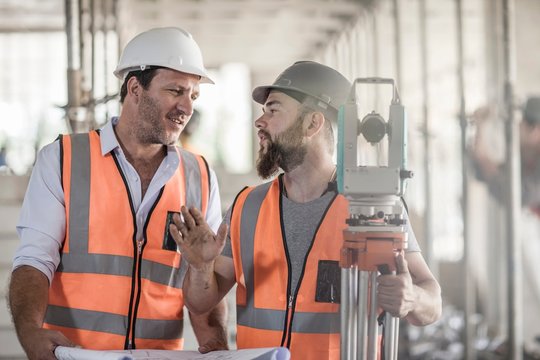 Surveyor explaining to site foreman on construction site
