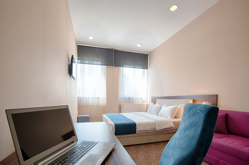 Interior of a modern hotel bedroom with laptop