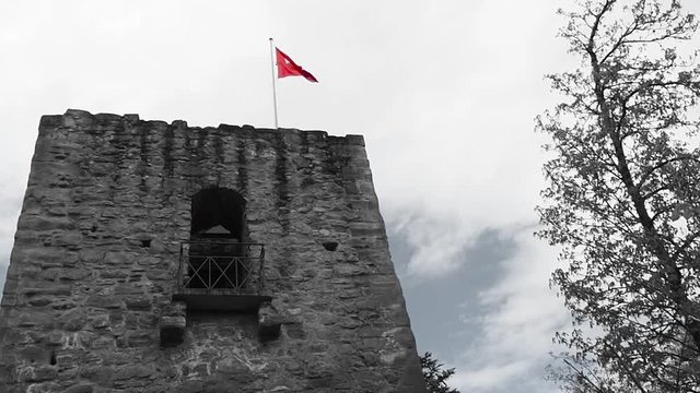 Swiss flag in the ruins of the old castle. Video in black and white format.