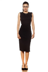 Fototapeta premium beautiful young woman in a tight black dress posing on a white