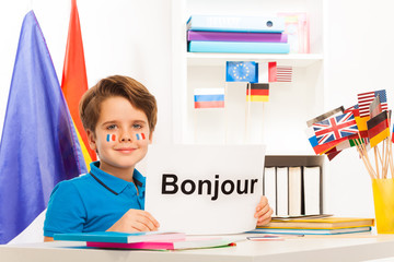 Boy learning French sitting at desk in classroom © Sergey Novikov