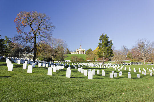Simple marble headstones in Section 31 at Arlington National Cemetery with Arlington House at the top of the hill in the distance, Virginia