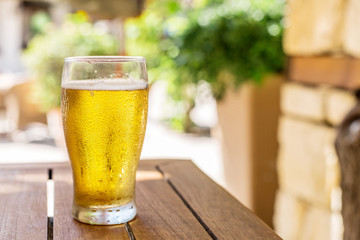 Glass of light beer on the wooden table.
