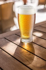 Sierkussen Glass of light beer on the wooden table. © volff
