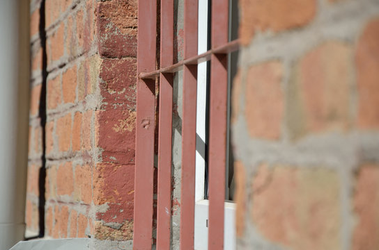 Window in brick wall protected with iron bars