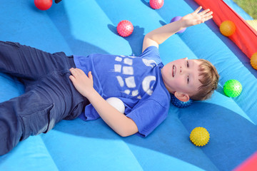 Handsome little boy lies on a bouncy castle