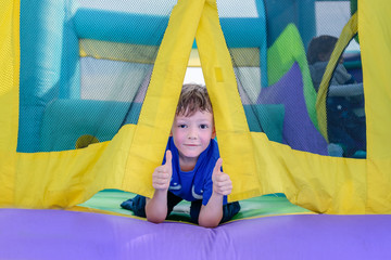 Fototapeta na wymiar Curious boy looking from entrance of bouncy house