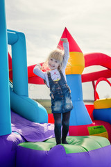 Excited girl waving from inflatable bouncy slide