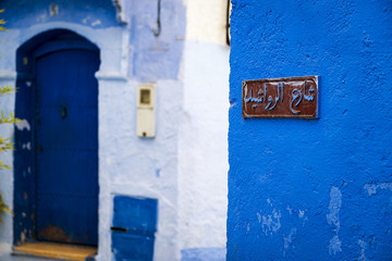 A plaque with a street name written in Arabic in the town of Chefchaouen in Morocco