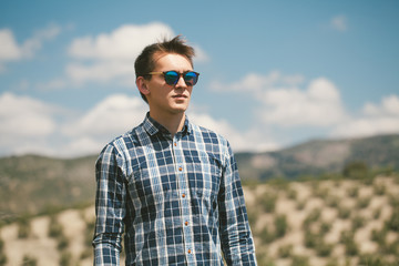 Naklejka na ściany i meble Young man in sunglasses posing at the spanish mountain range.