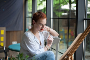 Fototapeta premium woman artist looking at her painting