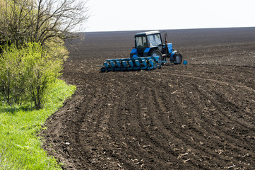 Obraz premium tractor in the field at planting