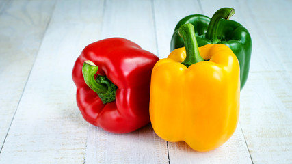 Fresh sweet Yellow, Red, Green Peppers on white table