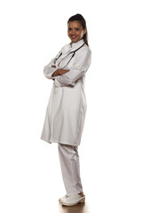 full length of a young woman doctor with arms folded