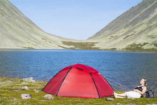 Female hiker camping near lake