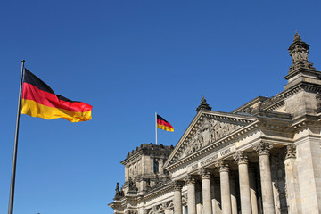 Fototapeta premium German flags and Reichstag building in Berlin, Germany