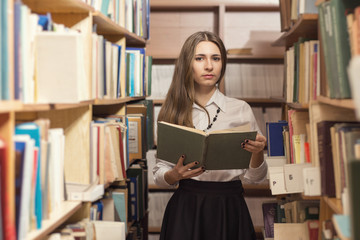 Girl reading book in library