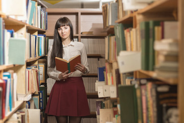 Girl reading book in library