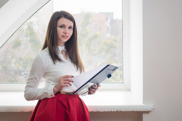 Beautiful girl in the office near the window