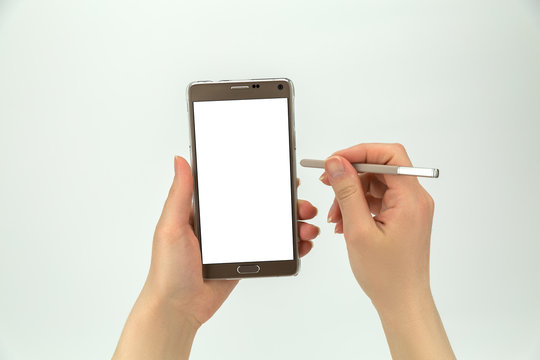 Big smartphone with white blank display and it's pen in hands isolated on the white background