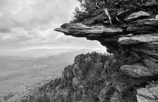 Fototapeta Black and white of a rocky weathered cliff jutting out from an Appalachian peak at Grandfather Mountain