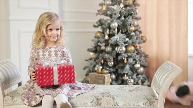 Little girl make christmas gift to her older sister