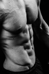 Closeup of cool perfect sexy strong sensual bare torso with abs pectorals 6 pack muscles chest black and white studio, vertical picture