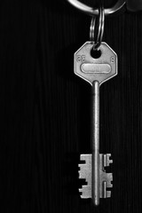 Iron key on dark background, black and white photo