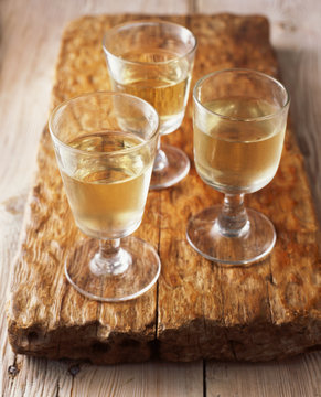 Glasses of white wine on wooden cutting board