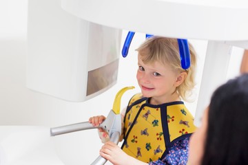 High angle view of girl in x-ray machine having dental examination smiling