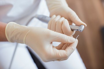 Cropped view of dental nurse wearing protective gloves preparing dental equipment