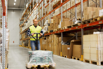 Fototapeta premium man carrying loader with goods at warehouse