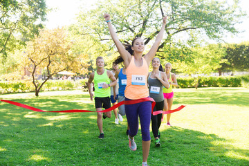 happy young female runner winning on race finish