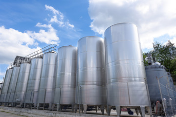 Metal wine barrels at a winery and blue sky with white clouds