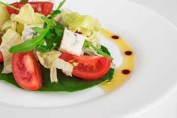 Fresh salad with spinach, cherry tomatoes, arugula and blue cheese. Close up image.