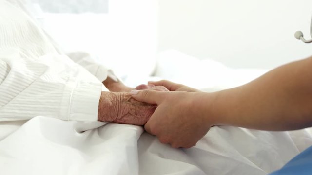 Nurse holding patient hands
