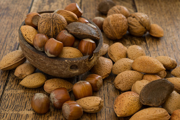 various mixed nuts on wooden table background