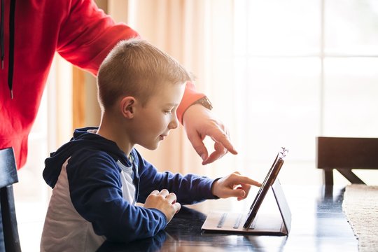 Father and son using wireless digital tablet at home