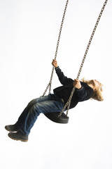 Little child blond girl having fun on a swing outdoor. Summer playground. Girl swinging high 