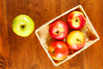 Juicy Sweet Apples In Basket On Wooden Table. Top view