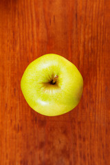 ripe green apples and apple slices on wooden gray background, top view