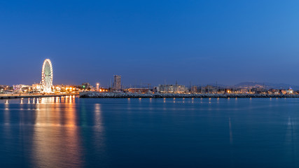Rimini waterfront cityscape at evening. Urban night lights