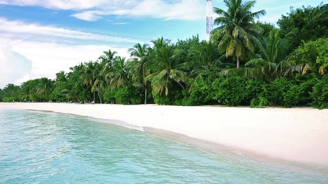 Tropical island with sandy beach with palm trees and tourquise clear water